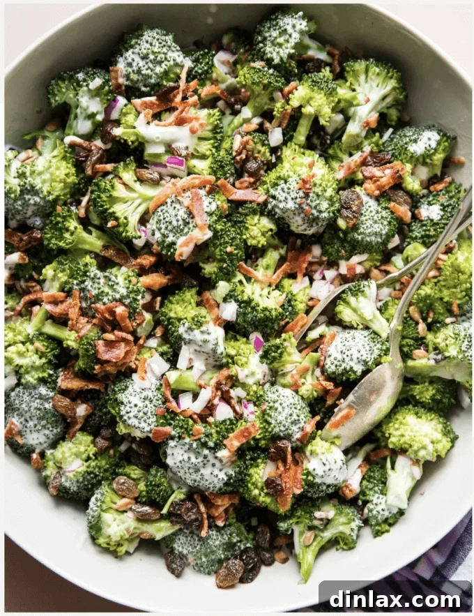 The Modern Proper's classic broccoli salad, featuring crisp bacon, diced red onion, and chewy raisins in a creamy dressing.
