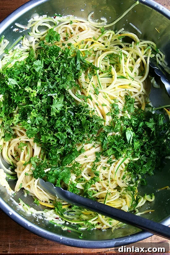 Fresh parsley and basil being added to spaghetti