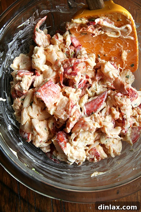 A beautifully assembled homemade lobster roll, showcasing the generous filling of lobster meat with tarragon mayonnaise, served on a toasted bun.