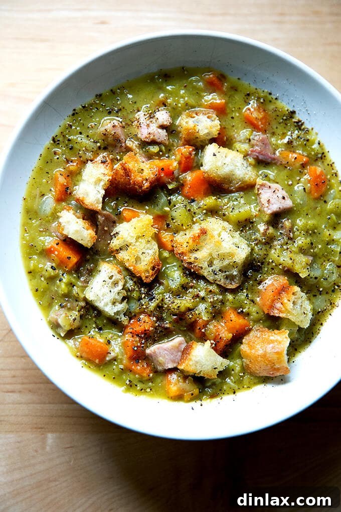 A heartwarming bowl of classic split pea and ham soup, garnished with golden olive oil croutons, ready to be enjoyed.