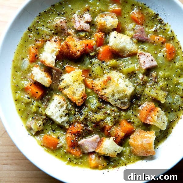 A bowl of split pea and ham soup topped with olive oil croutons.