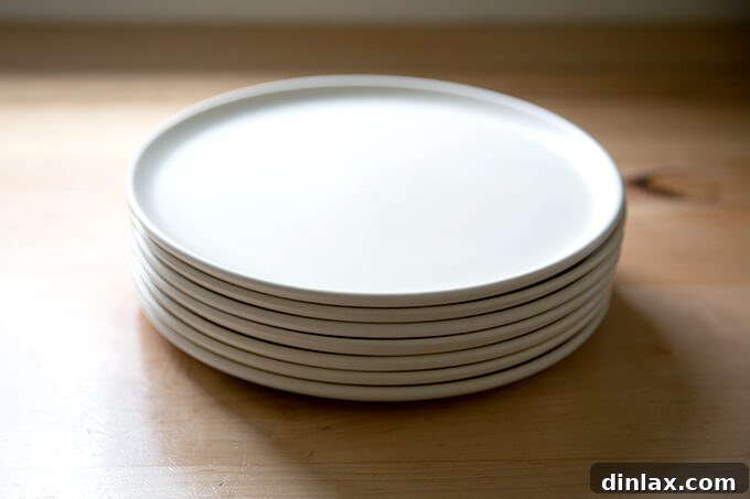 A stack of chic white dinner plates, a thoughtful kitchen gift for Mother's Day.