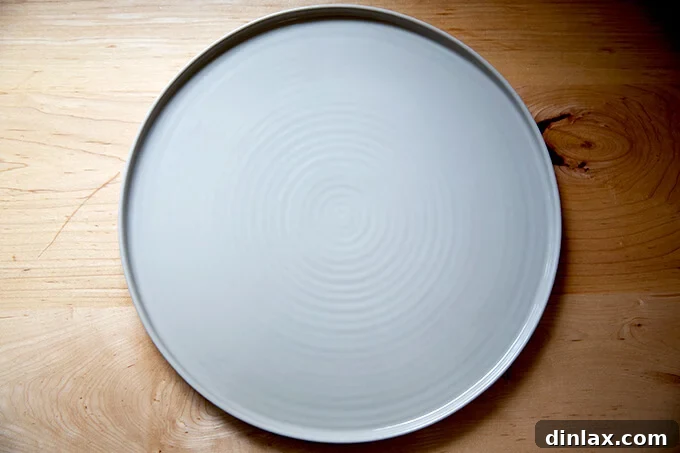 A large circular serving platter from Hawkins New York, ideal for elegant food presentation.