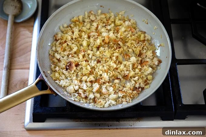 Golden brown, crispy toasted bread crumbs sizzling gently in a skillet, ready to add texture to the salad.