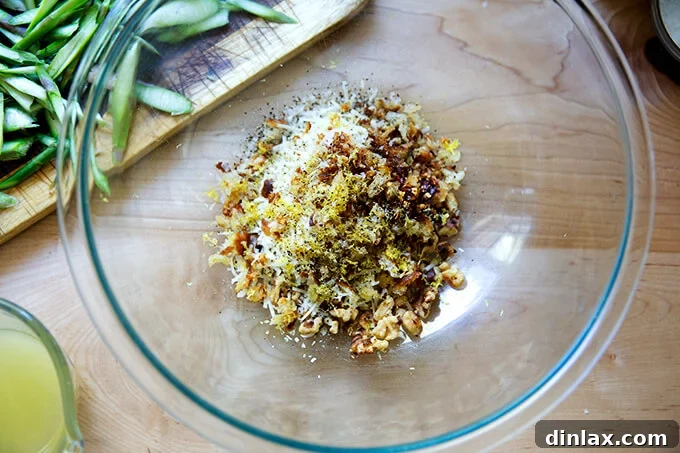 A bowl filled with a harmonious blend of toasted walnuts, crunchy bread crumbs, grated parmesan, and aromatic lemon zest.