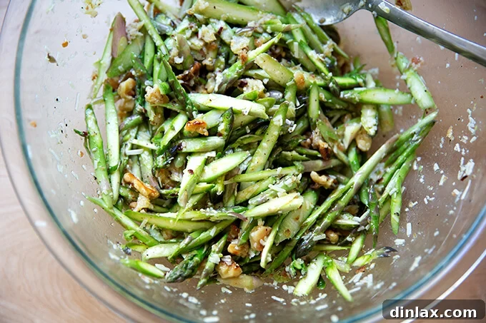 A large bowl of raw asparagus salad, perfectly dressed and tossed, showcasing its fresh ingredients and inviting texture.