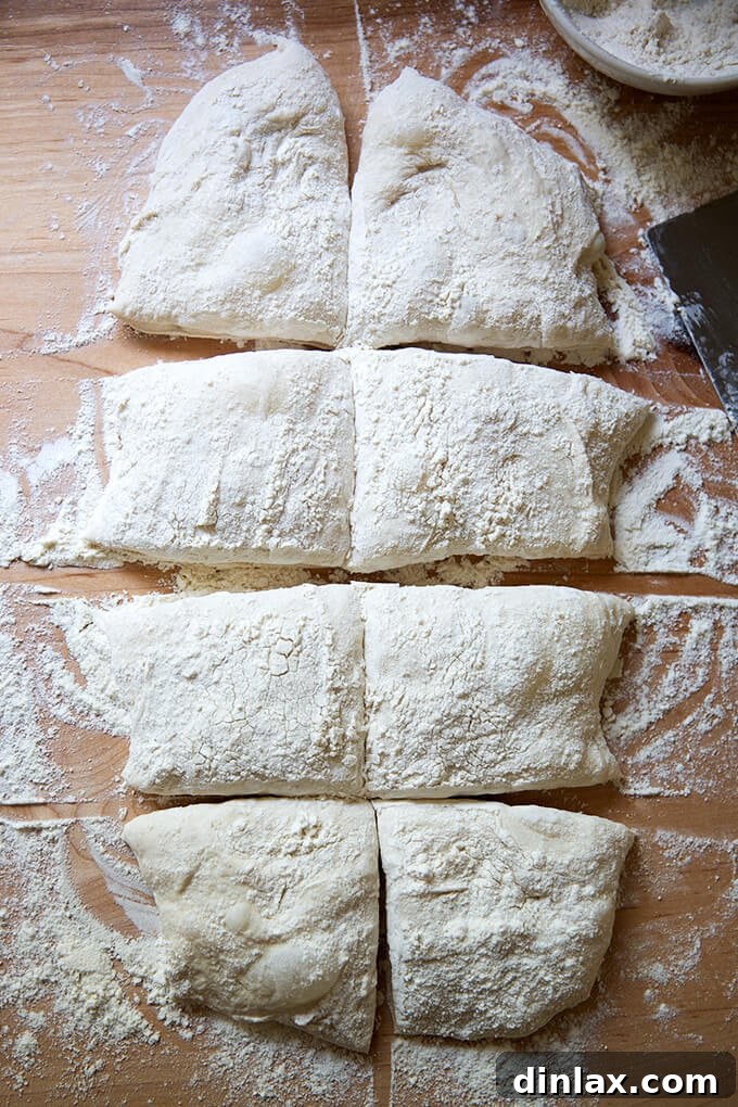 Ciabatta dough precisely cut into 8 individual portions using a bench scraper.