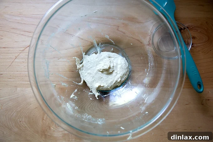 Freshly mixed poolish in a glass bowl, just covered and left to ferment.