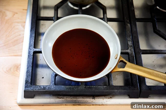 Effortless Balsamic Parmesan Roasted Asparagus 11 Dark balsamic vinegar simmering gently in a small non-stick skillet over low heat, beginning to reduce and thicken.