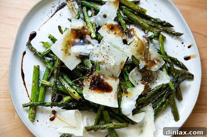Effortless Balsamic Parmesan Roasted Asparagus 9 Close-up of roasted asparagus with generous shavings of Parmesan cheese and a glistening drizzle of balsamic glaze.