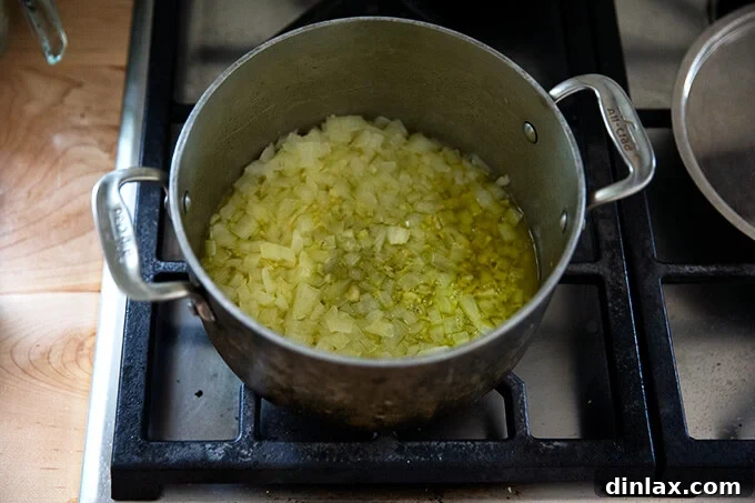 Pantry-Perfect Tomato Sauce in Minutes 6 A pot of minced onions and garlic simmering stovetop with olive oil.