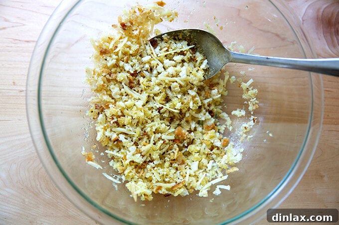 A bowl filled with a mixture of fresh bread crumbs, grated Parmesan, and olive oil.