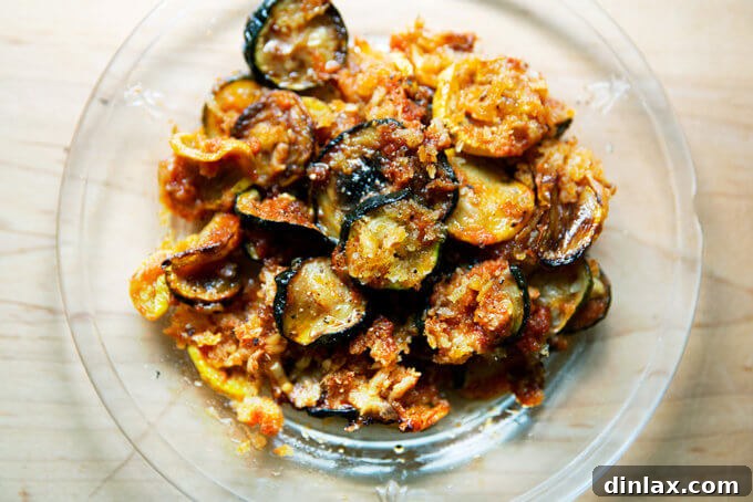 A perfect slice of just-baked zucchini parmesan on a white plate, showcasing its delicious layers.