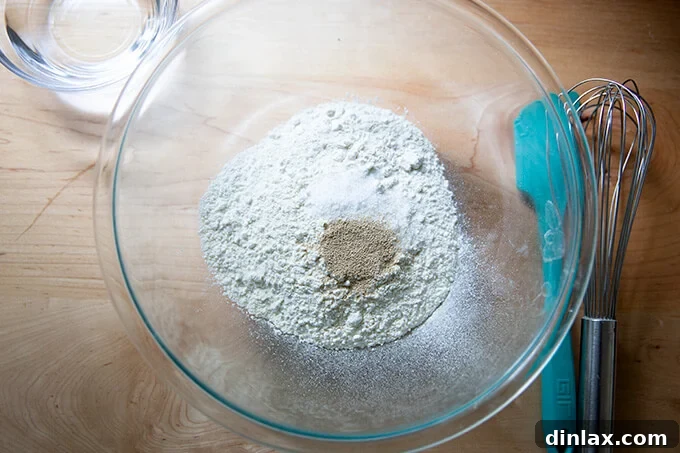 A large glass bowl filled with flour, salt and yeast.