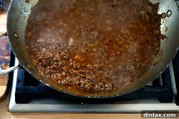 Taco meat gently simmering in a skillet, with the rich sauce bubbling and the flavors deepening as it cooks.