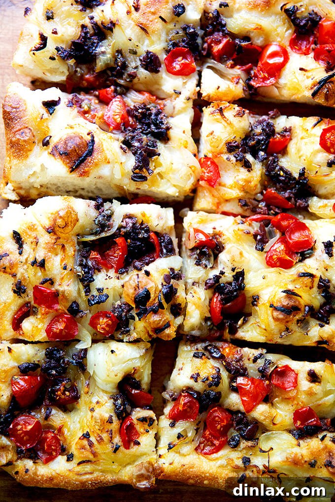 Several cut pieces of Pissaladière arranged artfully on a wooden board, showcasing its enticing layers and golden crust.