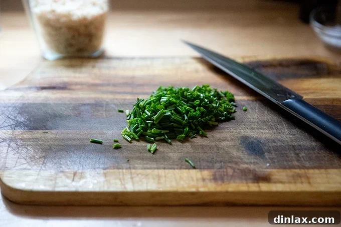 Chopped fresh chives on a cutting board, ready for garnish.
