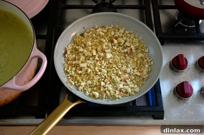 Breadcrumbs toasting in olive oil in a skillet.