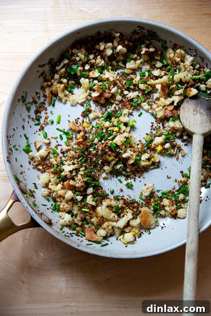 A close-up of fragrant gremolata breadcrumbs in a skillet.