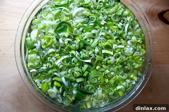 A large bowl of sliced leeks soaking in water to remove dirt.