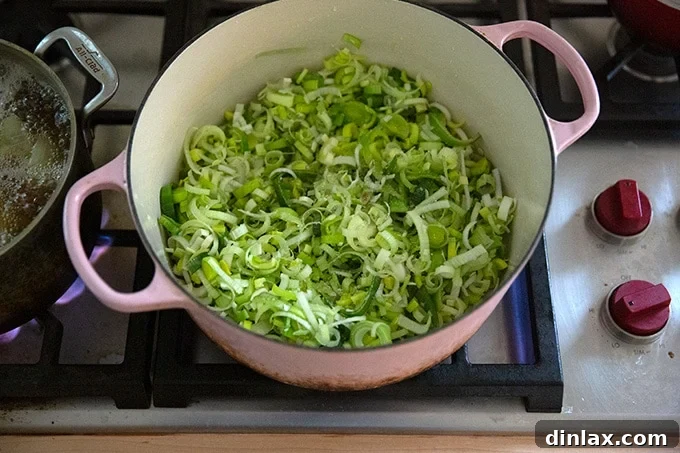 Leeks sautéing in olive oil in a large soup pot.