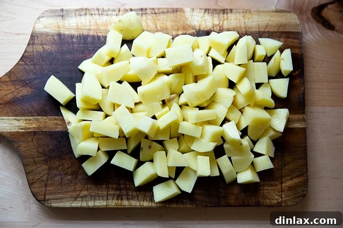 Peeled and diced Yukon Gold potatoes on a cutting board.
