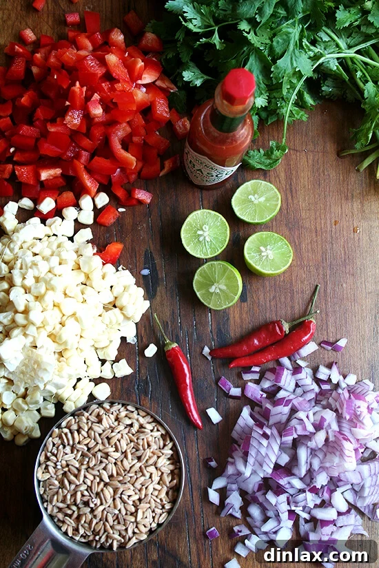 Fresh ingredients for a summer farro salad including corn, red peppers, red onion, cilantro, and lime.