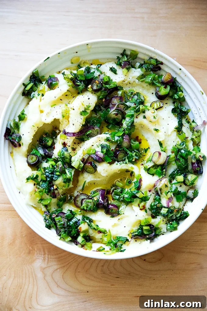 A bowl of herby buttermilk mashed potatoes, garnished with fresh herbs and a drizzle of olive oil, ready to be served.