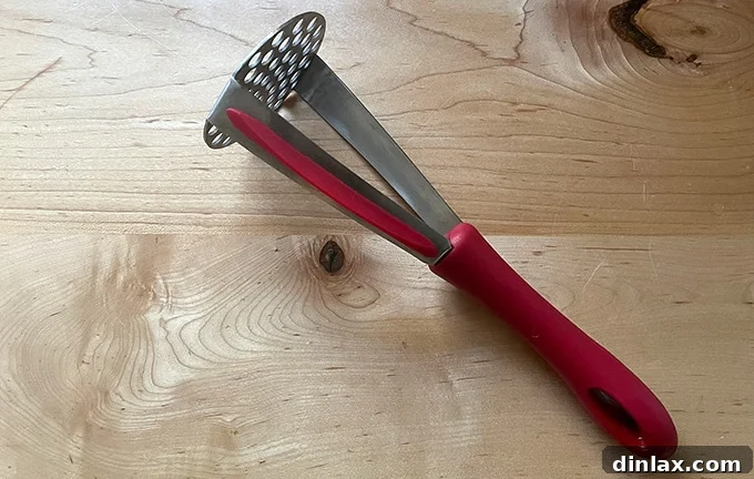 A sturdy potato masher resting on a clean kitchen countertop, highlighting its simplicity and effectiveness.
