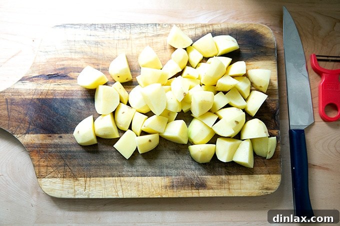 Peeled and uniformly chopped Yukon Gold potatoes in a bowl, prepared for cooking.