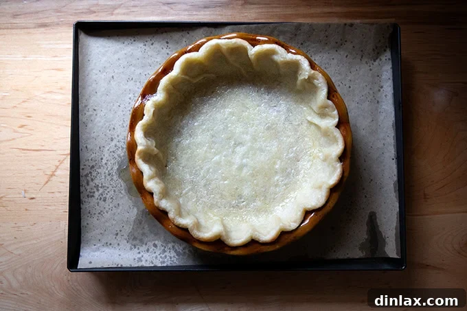 A pie plate lined with a parbaked pie crust.