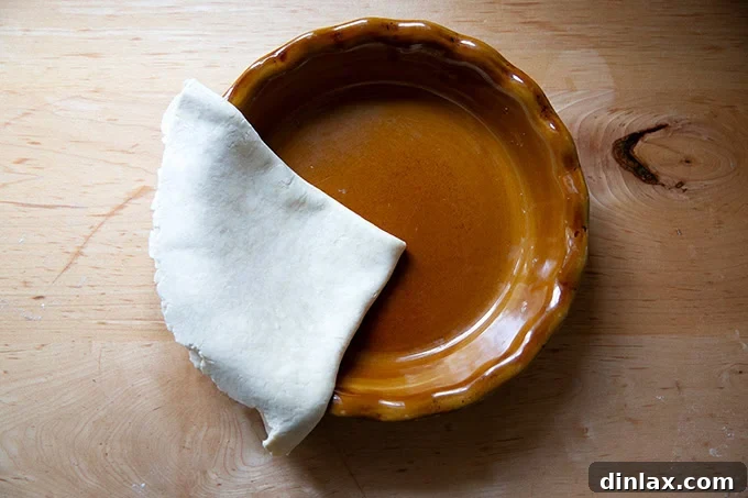 Folded pie dough in a pie plate.