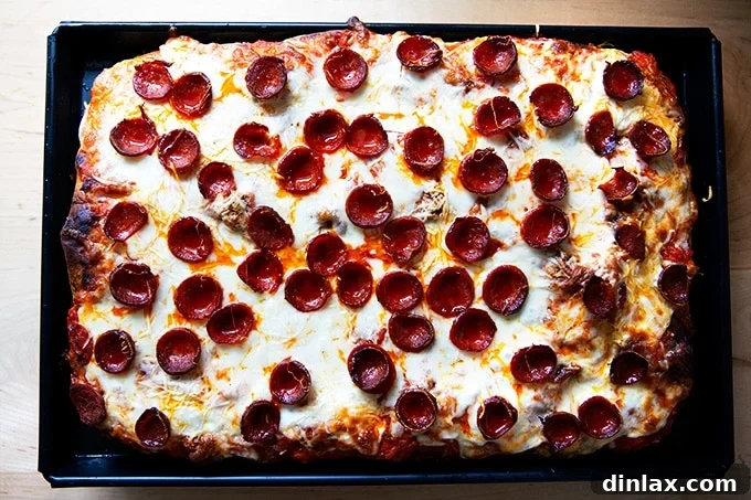 A freshly baked Sicilian-style pepperoni pizza, hot and bubbling, just out of the oven.