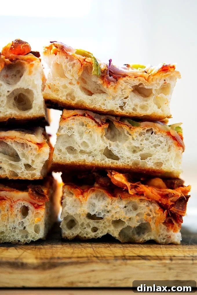 A tempting stack of perfectly baked Sicilian-style pizza squares, highlighting the crisp edges and airy texture.