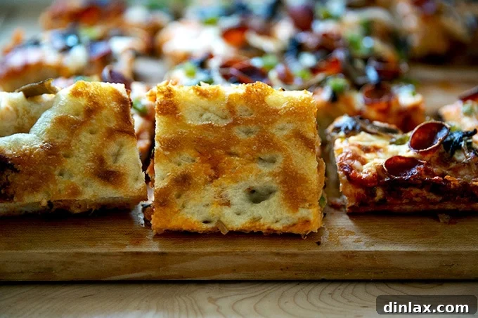 The golden-brown, perfectly crisp undercarriage of a single slice of homemade Sicilian-style pizza.