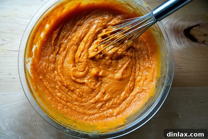 Sweet Potato Comfort Bake 10 Sweet potato filling in a large bowl with a whisk.