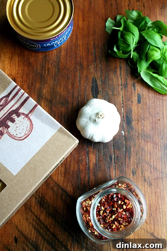Ingredients for Linguine with Roasted Red Peppers and Crabmeat Fresh ingredients laid out for summer linguine: pasta, garlic, red peppers, basil, and canned crab
