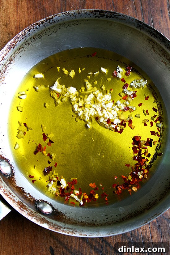 Garlic and Chili Infused Olive Oil Olive oil infused with garlic and red pepper flakes, sizzling gently in a skillet