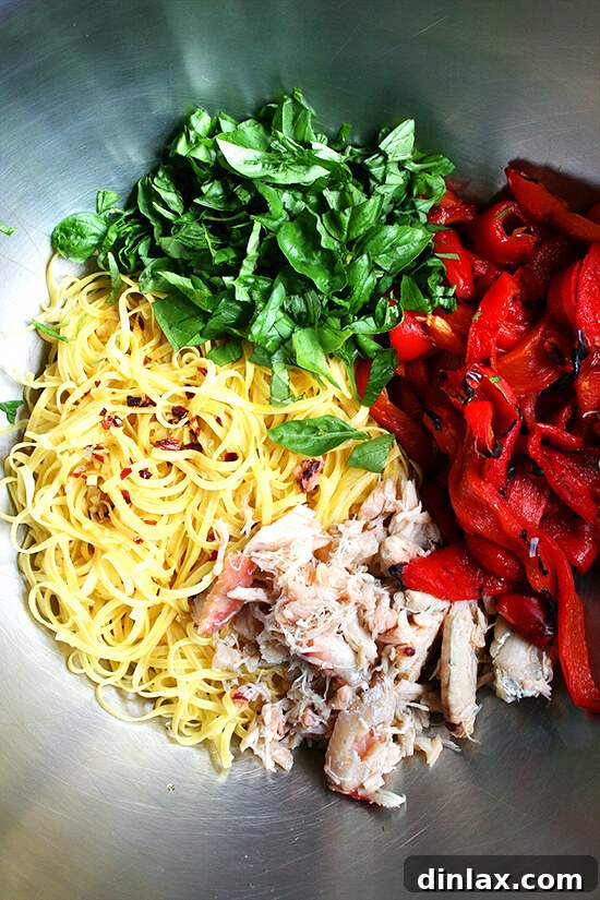 Components of the Crab and Roasted Red Pepper Linguine Cooked linguine, fresh basil leaves, tender crabmeat, and vibrant roasted red peppers arranged together
