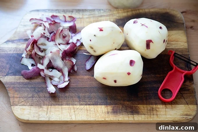 A pile of perfectly peeled potatoes, awaiting their turn to be diced and added to the soup.