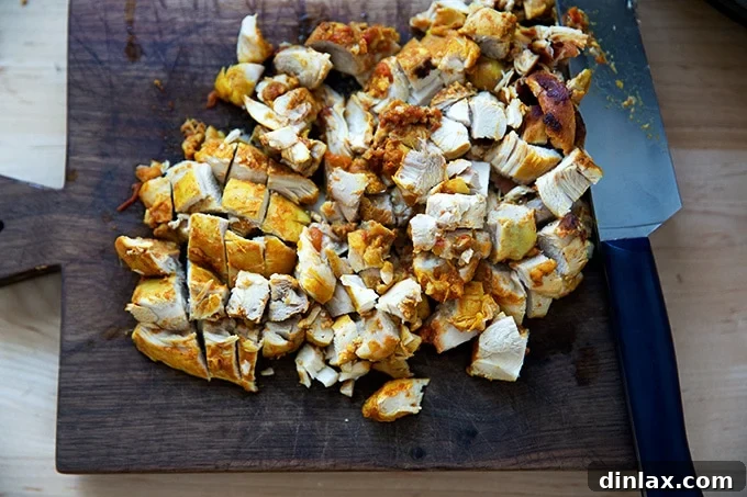 Effortless Butter Chicken and Chickpeas Instant Pot or Stovetop 12 Cooked chicken pieces from the Instant Pot, chopped and arranged on a wooden cutting board.