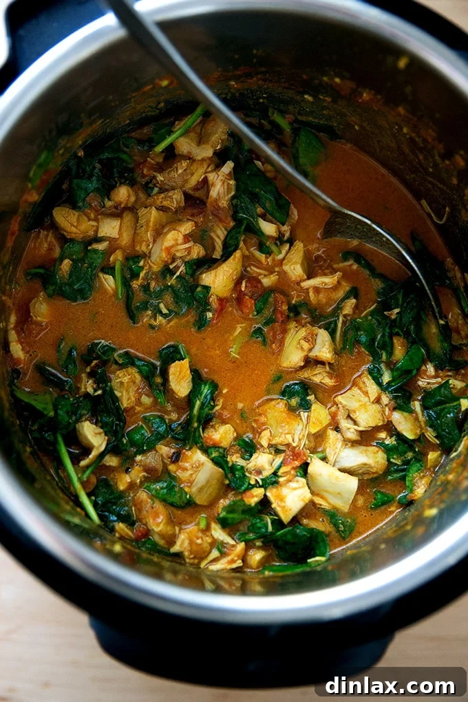 Effortless Butter Chicken and Chickpeas Instant Pot or Stovetop 15 The Instant Pot with butter chicken and wilted spinach, showing the greens fully incorporated into the rich sauce.