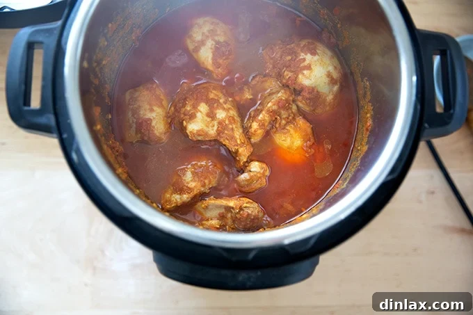 Effortless Butter Chicken and Chickpeas Instant Pot or Stovetop 10 The Instant Pot's interior revealing the perfectly cooked butter chicken with tender chicken pieces submerged in the rich, reddish sauce.
