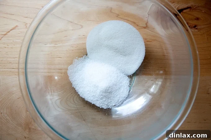 Simply Irresistible Grilled Chicken Breasts 6 A large glass bowl containing 1/4 cup each of salt and sugar, ready for brining liquid preparation.