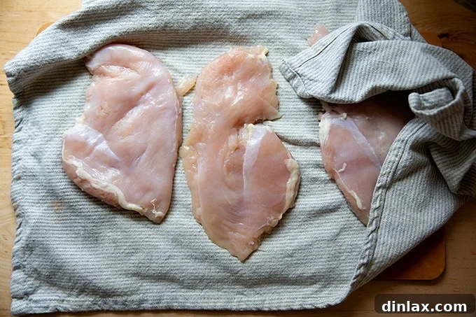 Simply Irresistible Grilled Chicken Breasts 8 Chicken breasts being gently patted dry with a tea towel, preparing them for the next step.