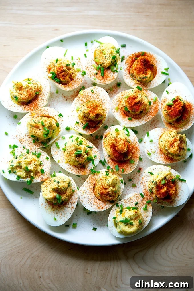 Timeless Deviled Delights 14 A finished plate of classic deviled eggs, garnished with chives and paprika.