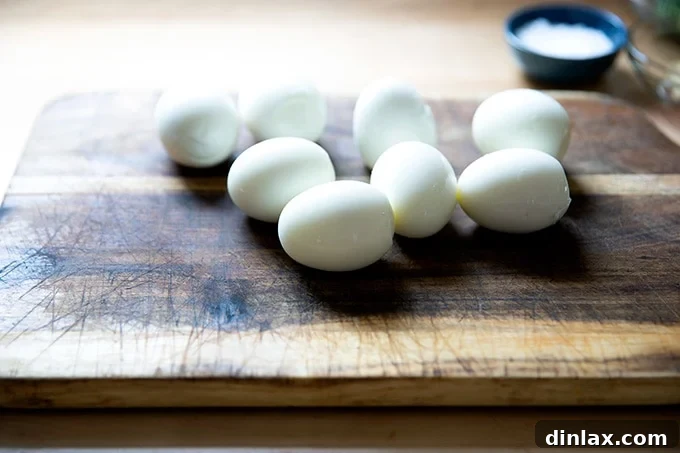 Timeless Deviled Delights 6 Eight perfectly peeled hard-cooked eggs resting on a cutting board, ready for the next step.