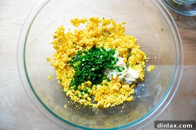 Timeless Deviled Delights 10 All filling ingredients – mashed yolks, chives, mayonnaise, mustard, and pickle juice – combined in a bowl.