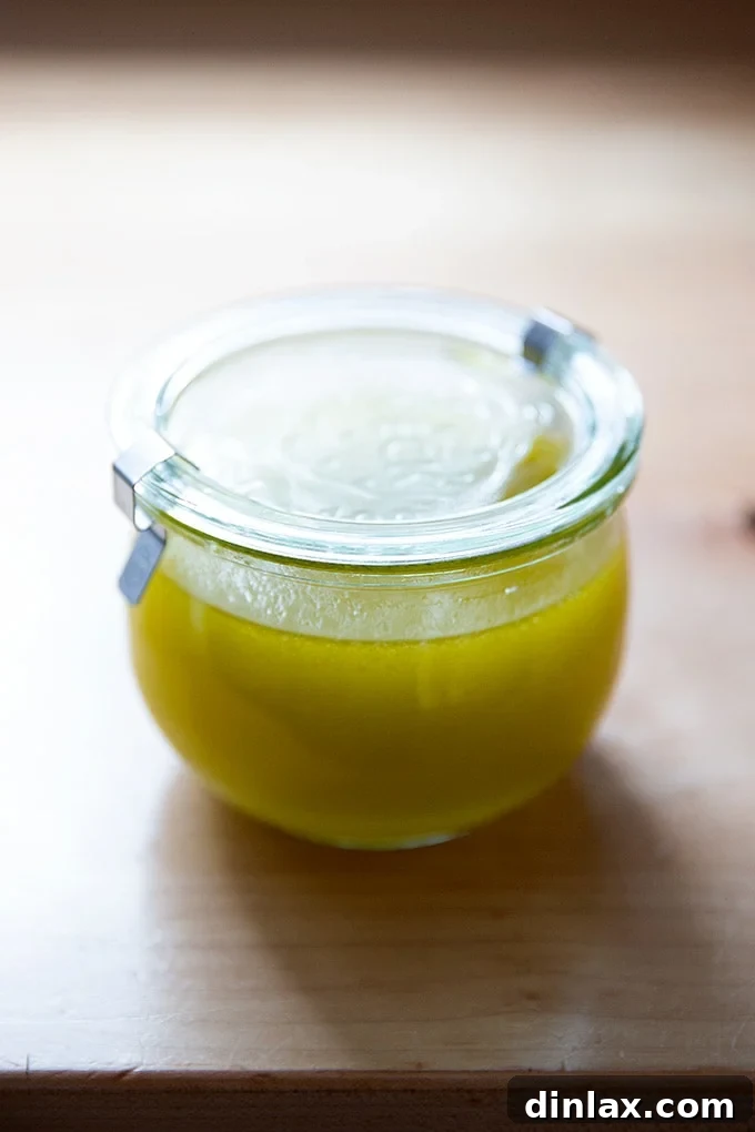 A clear jar filled with homemade lemon vinaigrette, ready to dress a fresh salad.