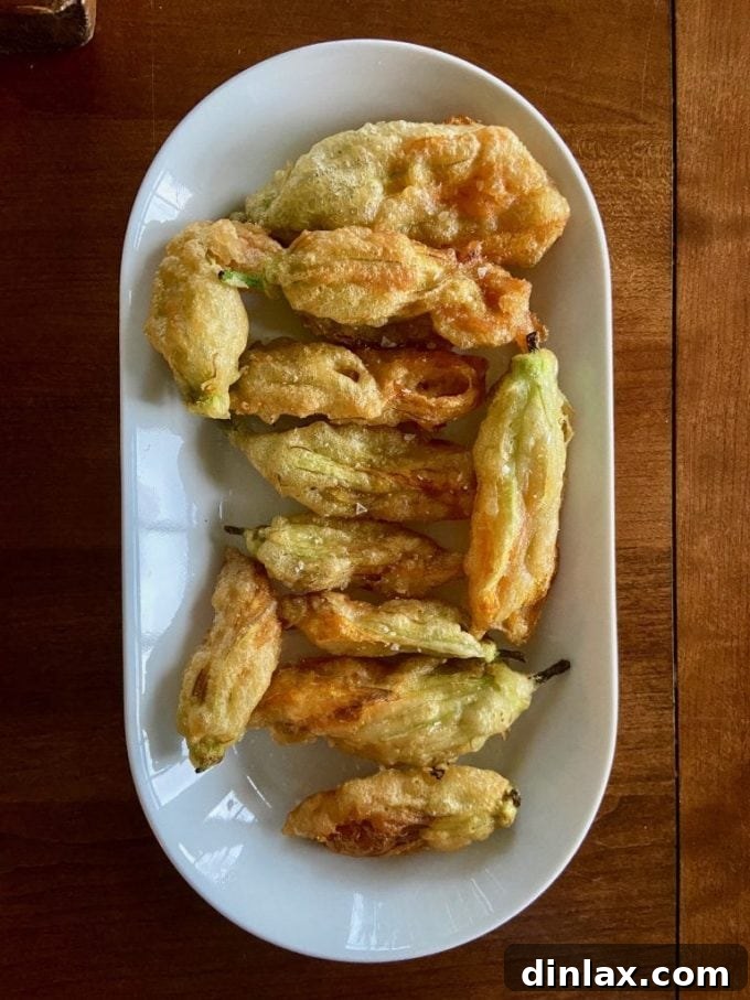 Zucchini Mastery: Margaret Roach's 20 Go-To Recipes 3 Crispy fried zucchini blossoms, lightly golden and presented beautifully, showcasing their delicate form.